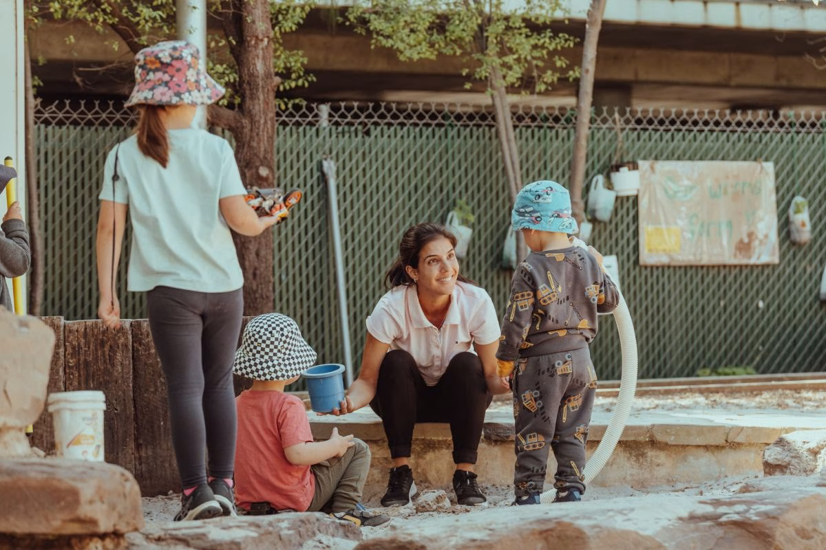 carer-playing-with-children-outside.avif