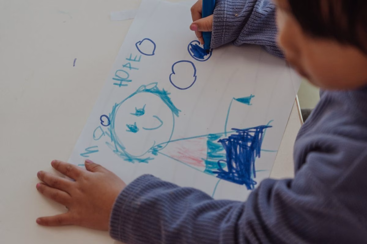 child-drawing-a-picture-of-a-person.avif