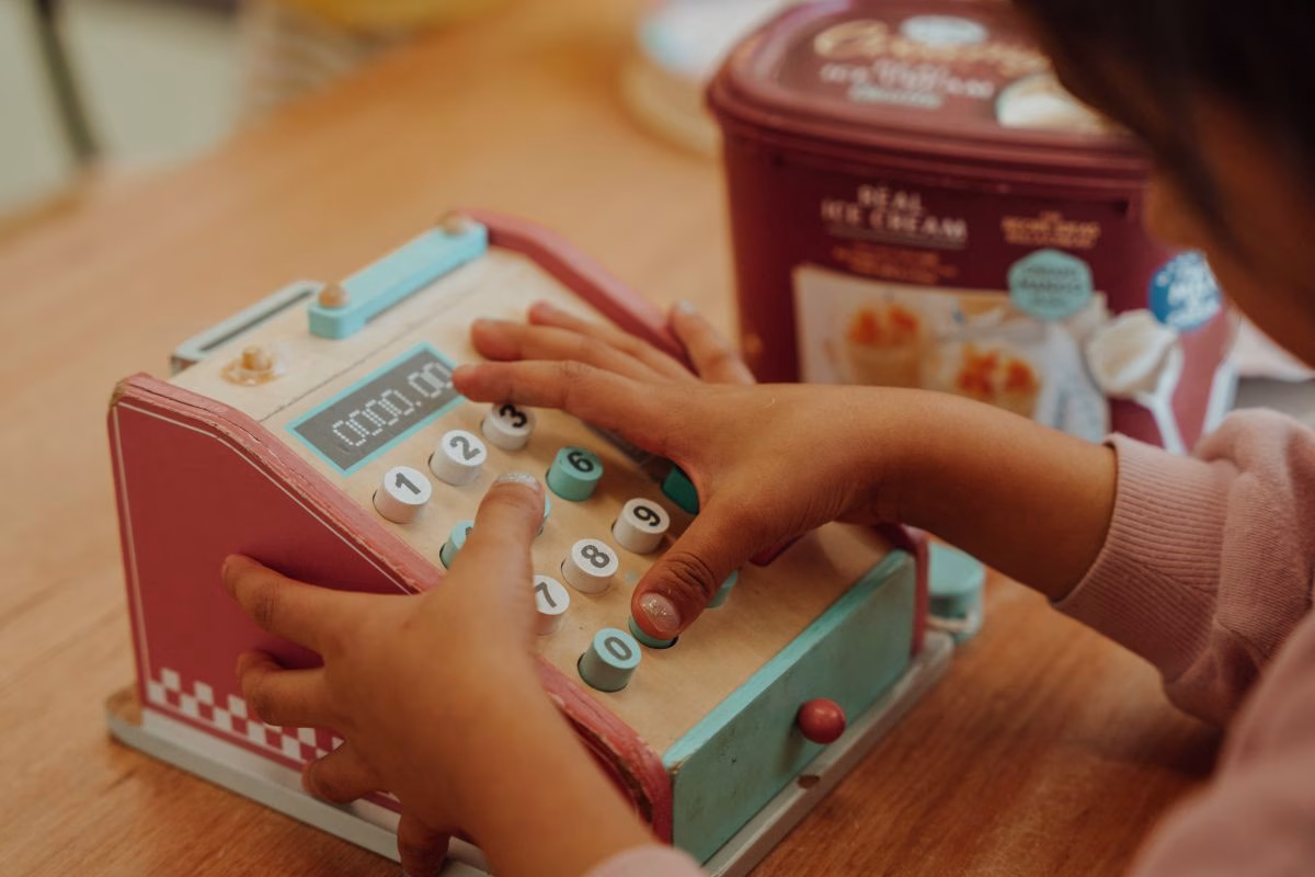 child-playing-with-toy-cash-register.avif